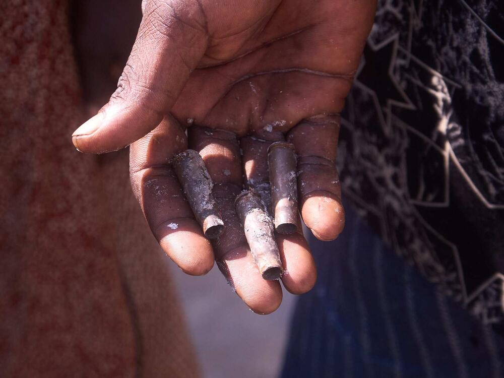 Terhemba Iormba holds bullet casings covered in ash. His family members were killed during an attack in Yelwata Village, central Nigeria in mid-June.