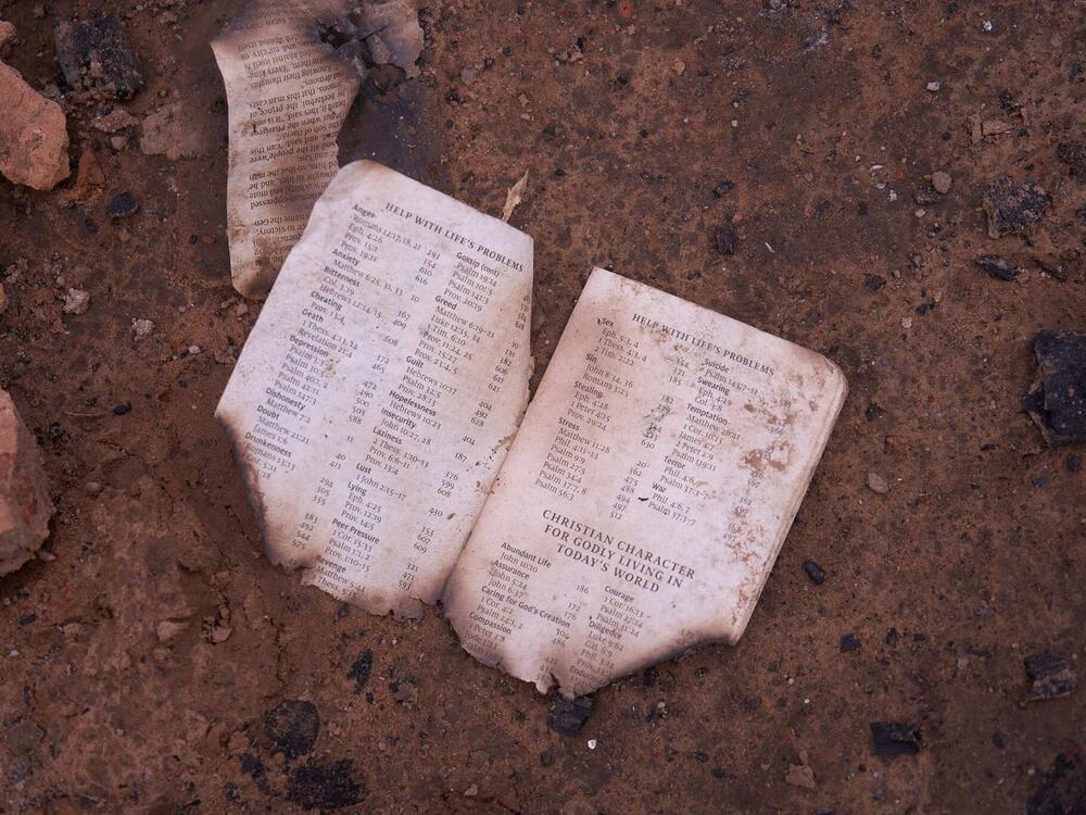 A burned Christian text is seen on the ground in Yelwata Village, after the attacks in mid-June.