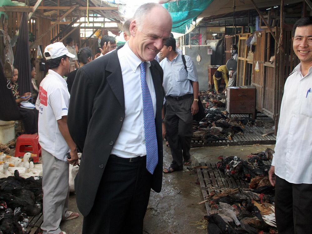 As the U.N.'s senior coordinator on avian influenza, David Nabarro )center) visited a fowl market in Phnom Penh in 2006.  The United Nations praised Cambodia for its rapid actions in preventing the spread of bird flu.
