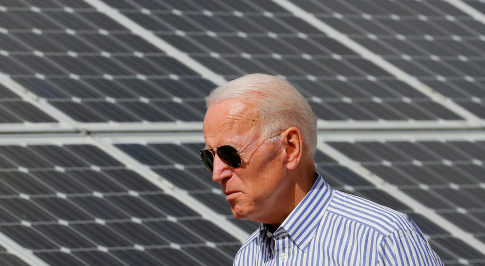 FILE PHOTO: Democratic 2020 U.S. presidential candidate and former Vice President Joe Biden walks past solar panels while touring the Plymouth Area Renewable Energy Initiative in Plymouth, New Hampshire, U.S., June 4, 2019. REUTERS/Brian Snyder/File Photo