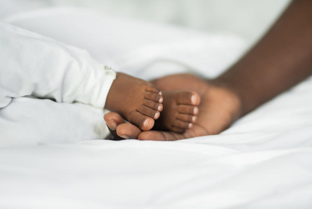 Cropped shot of a man touching his baby's feet