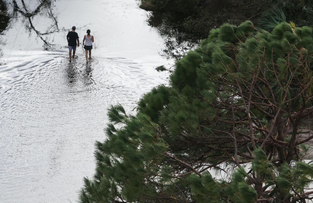 A couple walking down a flooded street after Hurricane Ian caused widespread destruction in Punta Gorda, Florida, on Sept. 29, 2022. File photo by REUTERS/Shannon Stapleton