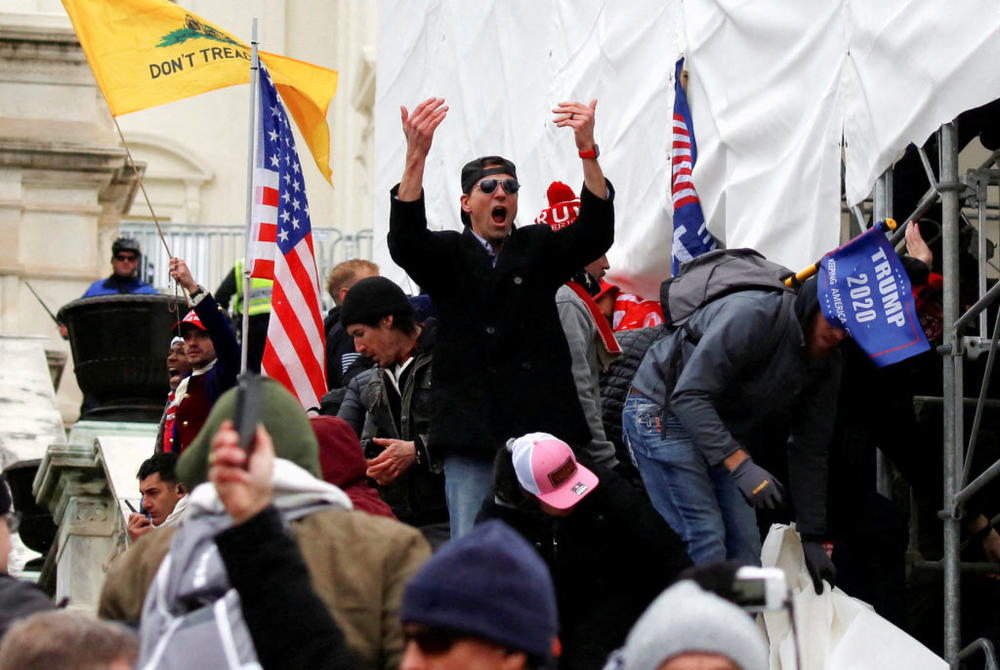 A man, identified as Ryan Kelley in a sworn statement by an FBI agent, gestures as supporters of U.S. President Donald Trump make their way past barriers at the U.S. Capitol during a protest against the certification of the 2020 U.S. presidential election results by the U.S. Congress, in Washington, U.S., January 6, 2021. REUTERS/Jim Urquhart