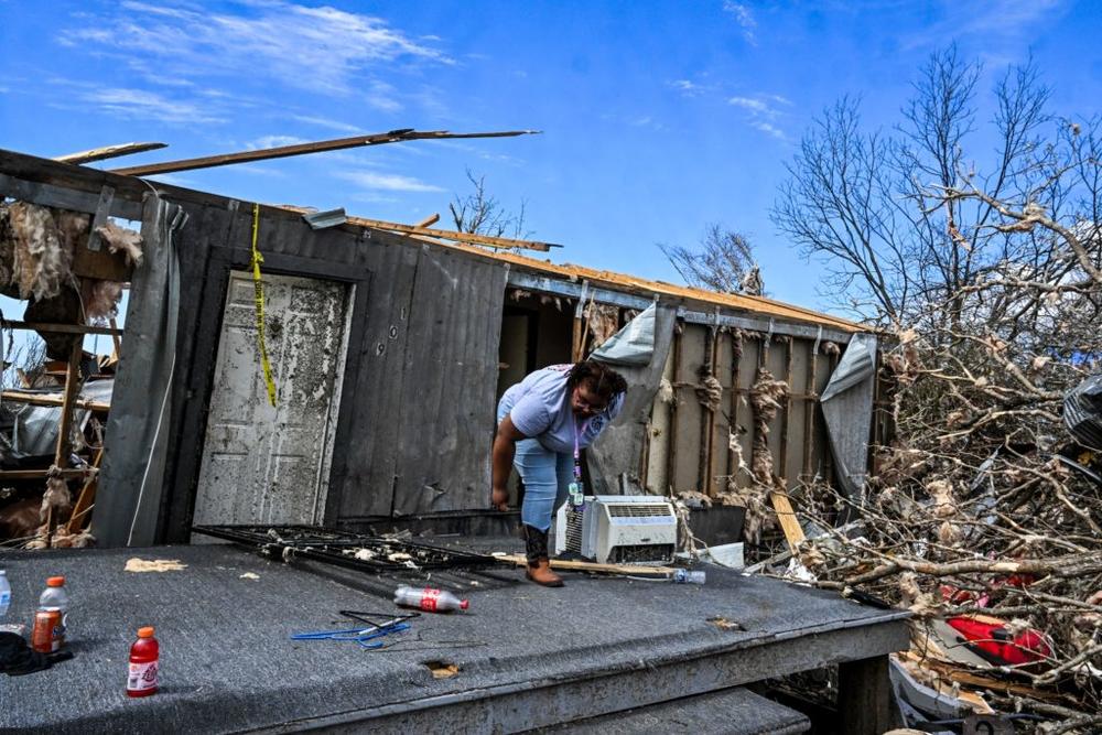 A family member of Earnestine Hilu walks out of her destroyed house in the aftermath of a tornado in Silver City, Mississippi, on March 26, 2023. Photo by Chandan Khanna/AFP via Getty Images