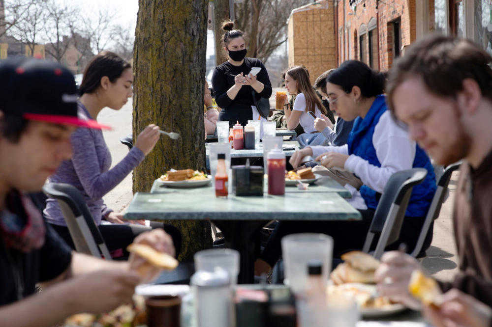 FILE PHOTO: People crowd outdoor seating at a restaurant as coronavirus disease (COVID-19) restrictions are eased in Ann Arbor, Michigan, U.S., April 4, 2021.  REUTERS/Emily Elconin/File Photo