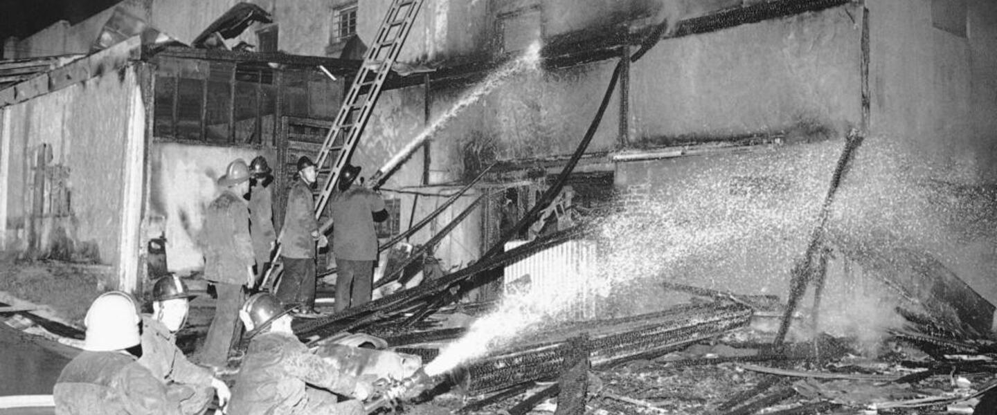 Firemen spray a stream of water on the burned-out shell of a grocery store in Augusta, Ga., May 12, 1970.