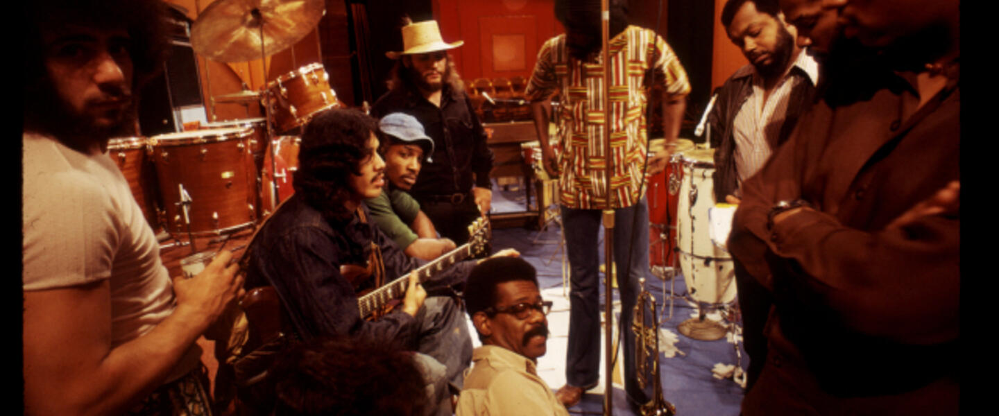 Men standing and seated with musical instruments.