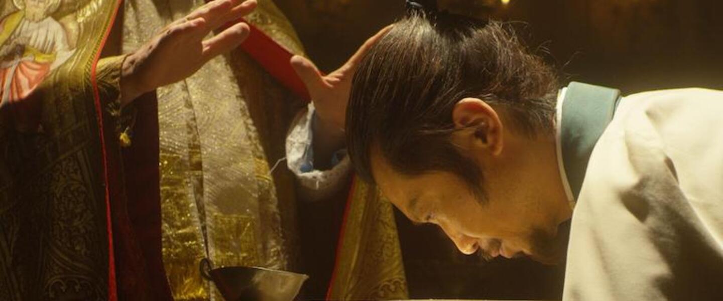 A Japanese man participates in a Catholic ceremony.