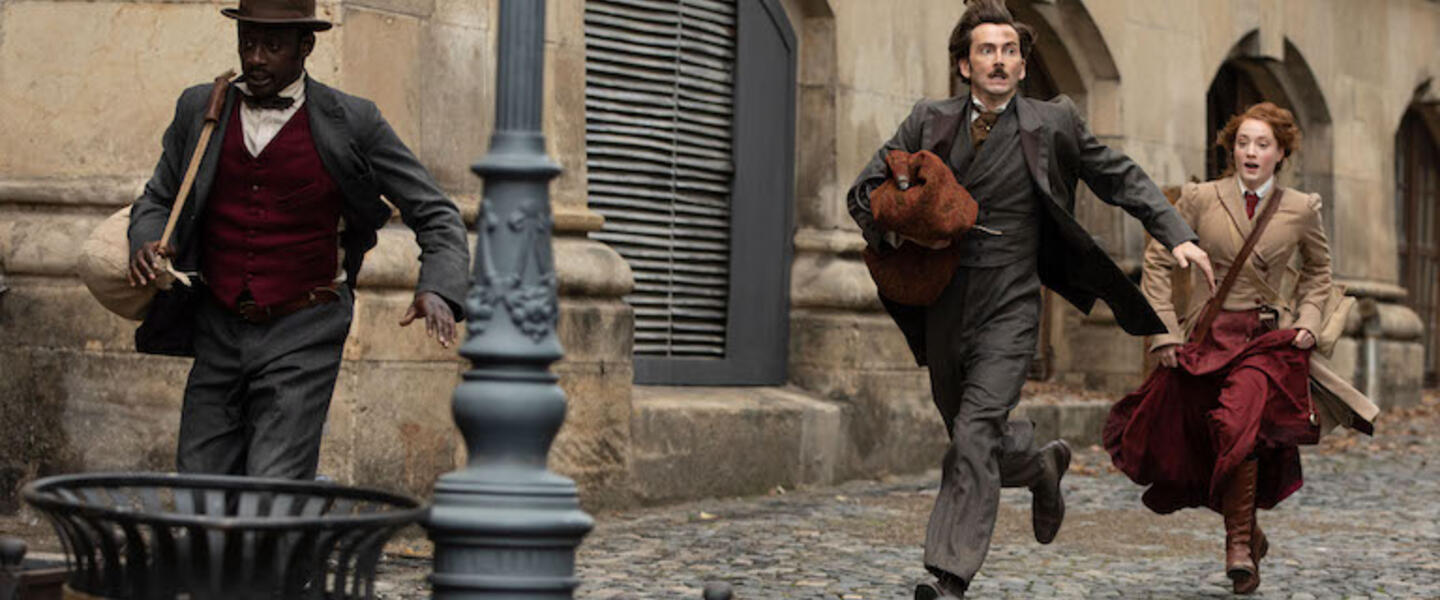 The cast of Around the World in 80 Days runs in period costume.