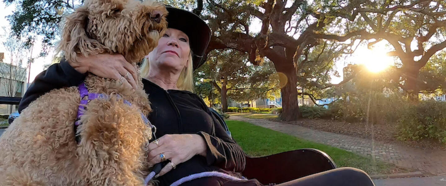 Sharon Collins and her dog Jessi on a park bench.