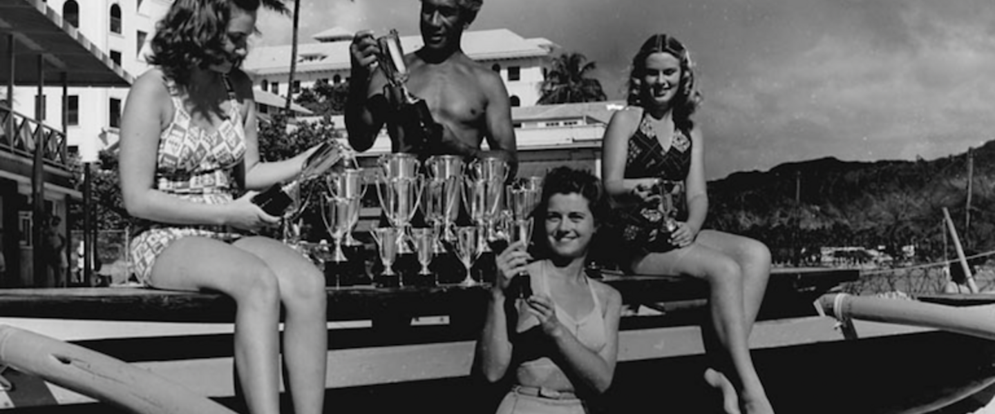 Duke Kahanamoku with his trophies and female friends.