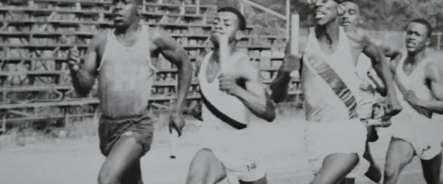 Young men racing in a black and white photo.