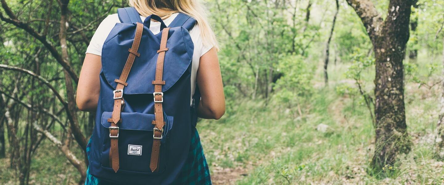 woman backpacking in woods