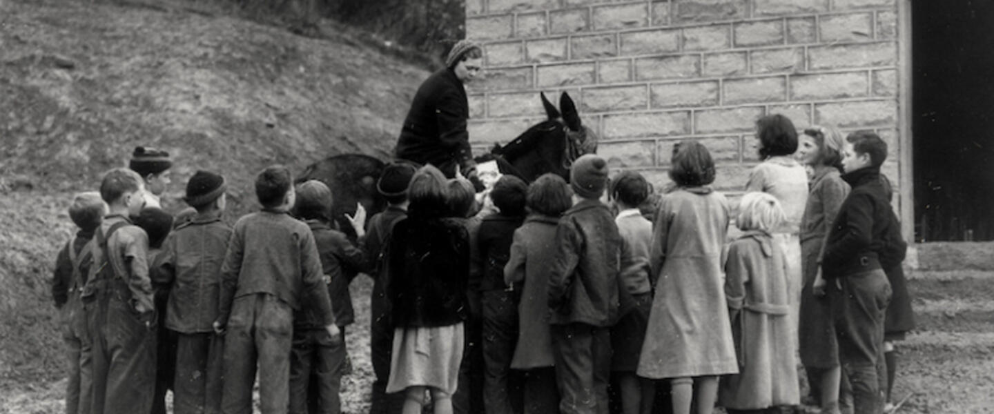 A librarian on horseback in a black and white picture.