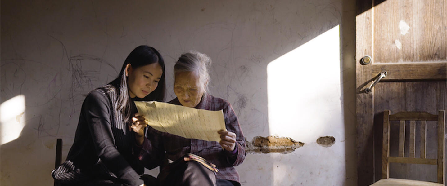 Two women examine a document.