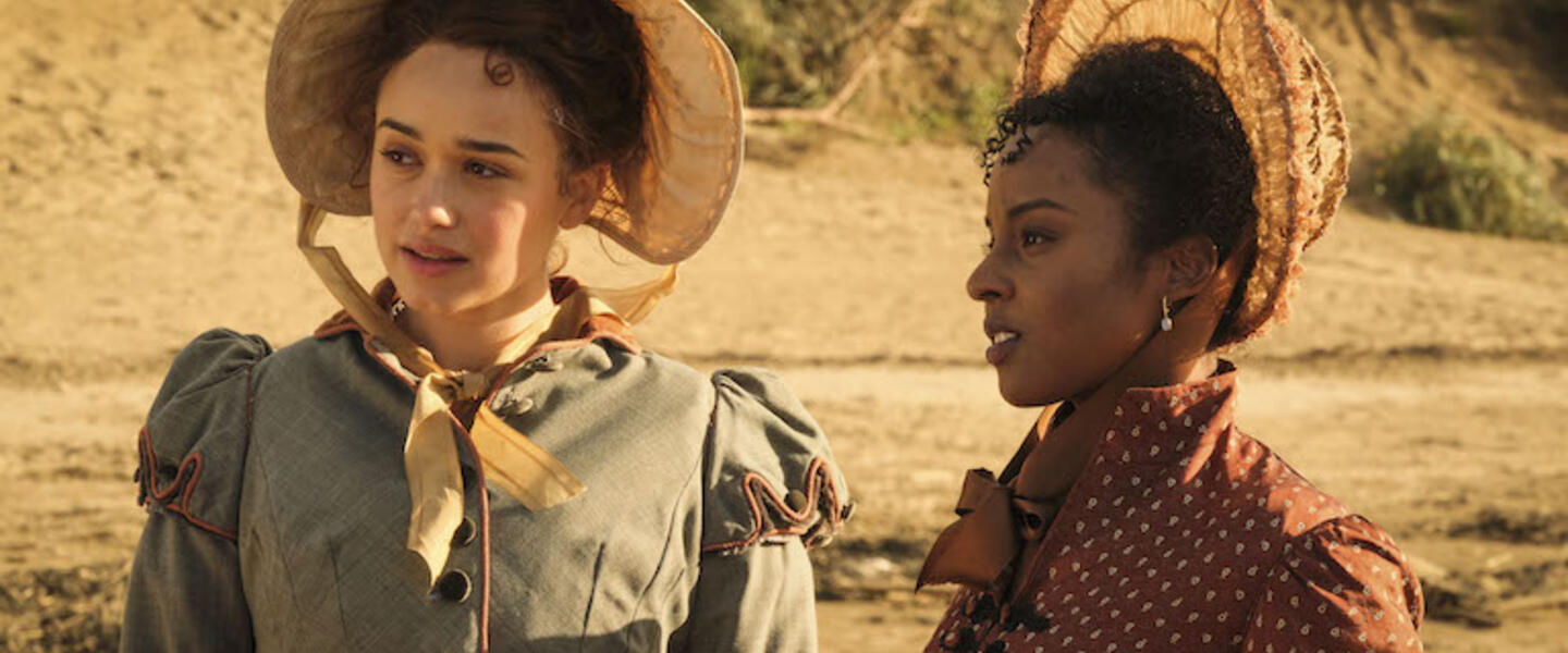 Cast of Sanditon in period dress on a beach.
