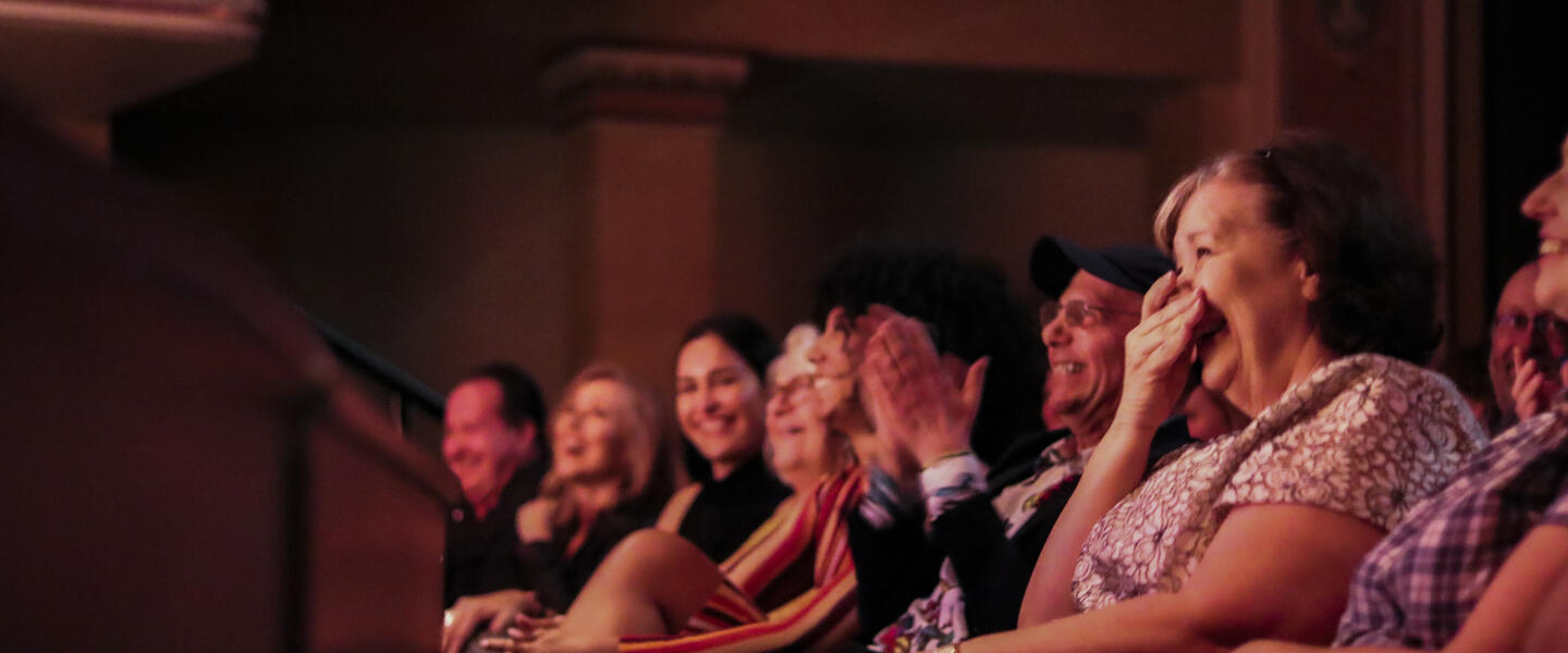 Audience members laughing at the Moth Mainstage