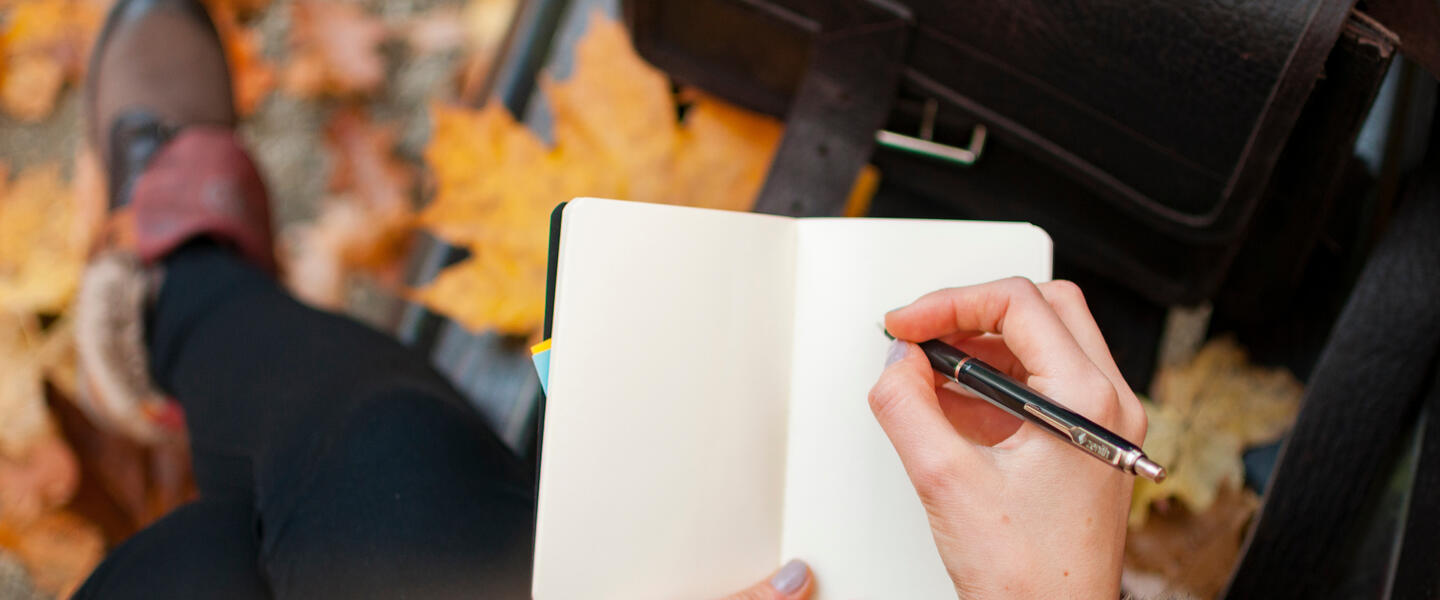 Someone writing with a pen on a page
