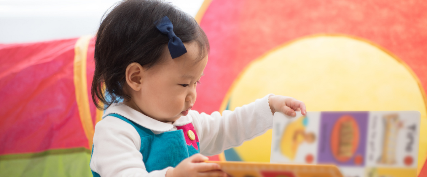 A baby explores a book