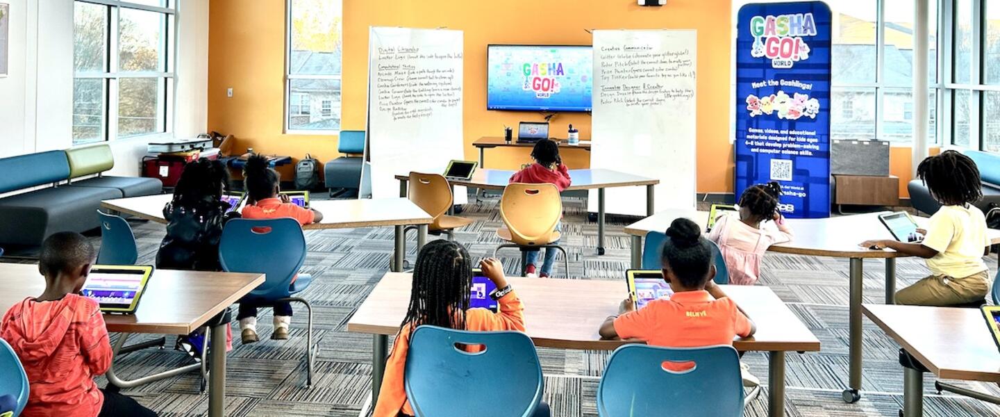 Kids try out the GASHA GO! World games during Day of Code