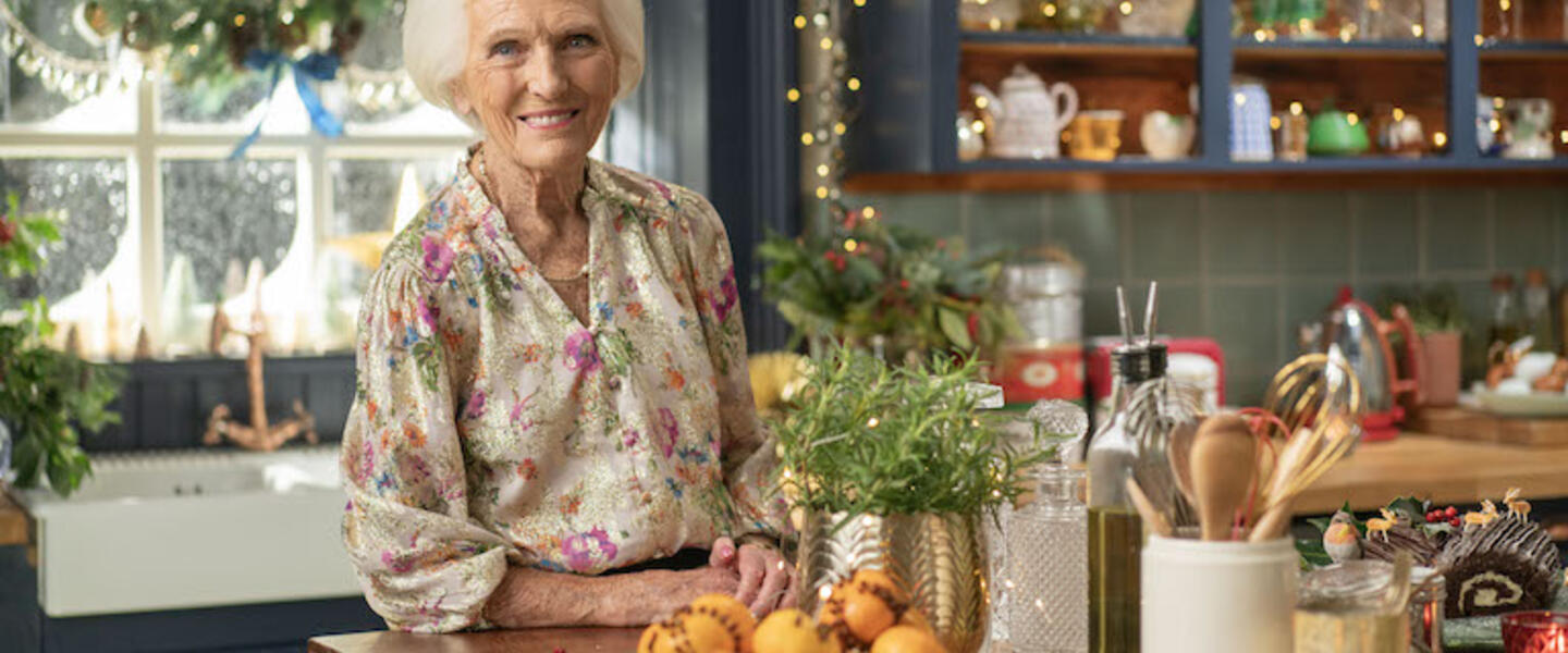 Mary Berry in a kitchen filled with food and Christmas decorations.