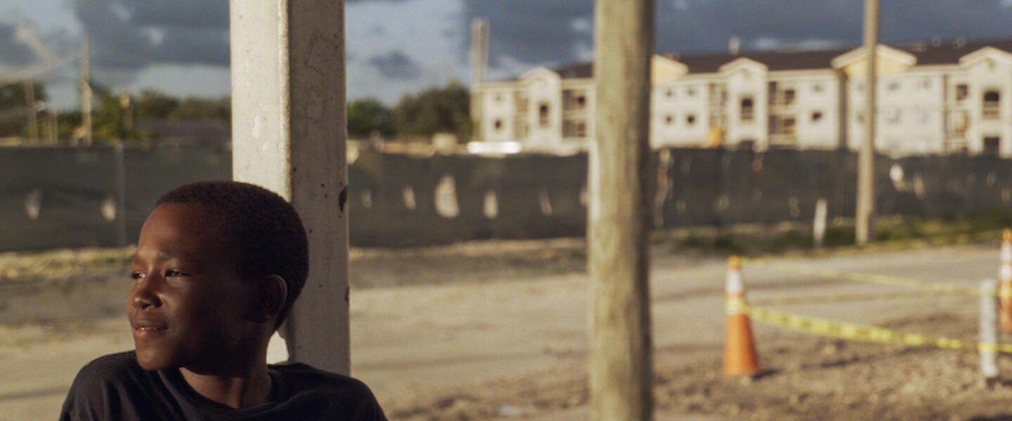 A little boy staring off into the distance with a slight smile.