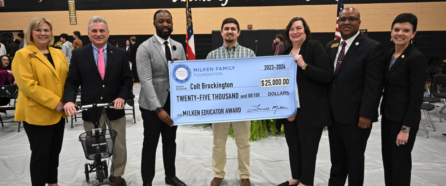 Colt Brockington holds $25,000 check from the Milken Family Foundation.