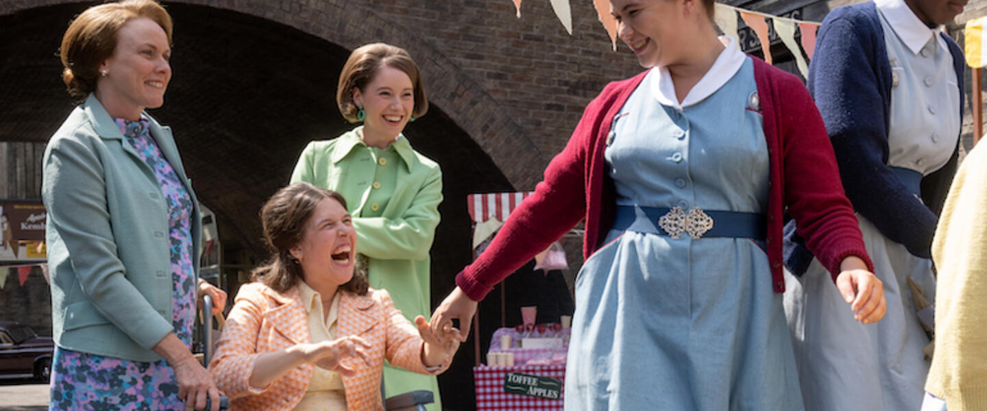 An image from Call the Midwife with a midwife and 3 women at a party outdoors.