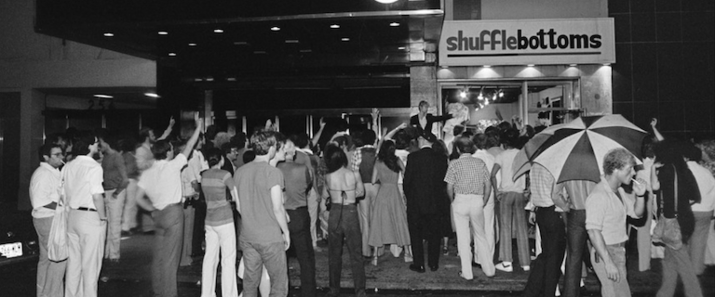 A black and white photo of people standing outside of Studio 54.