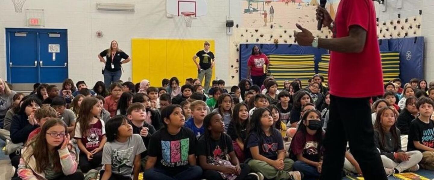 Malcolm Mitchell speaks to a gym full of elementary aged children.