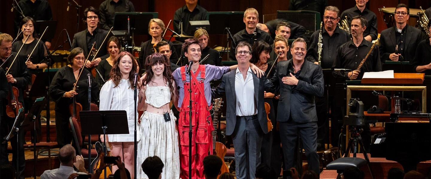 Musicians standing on stage.
