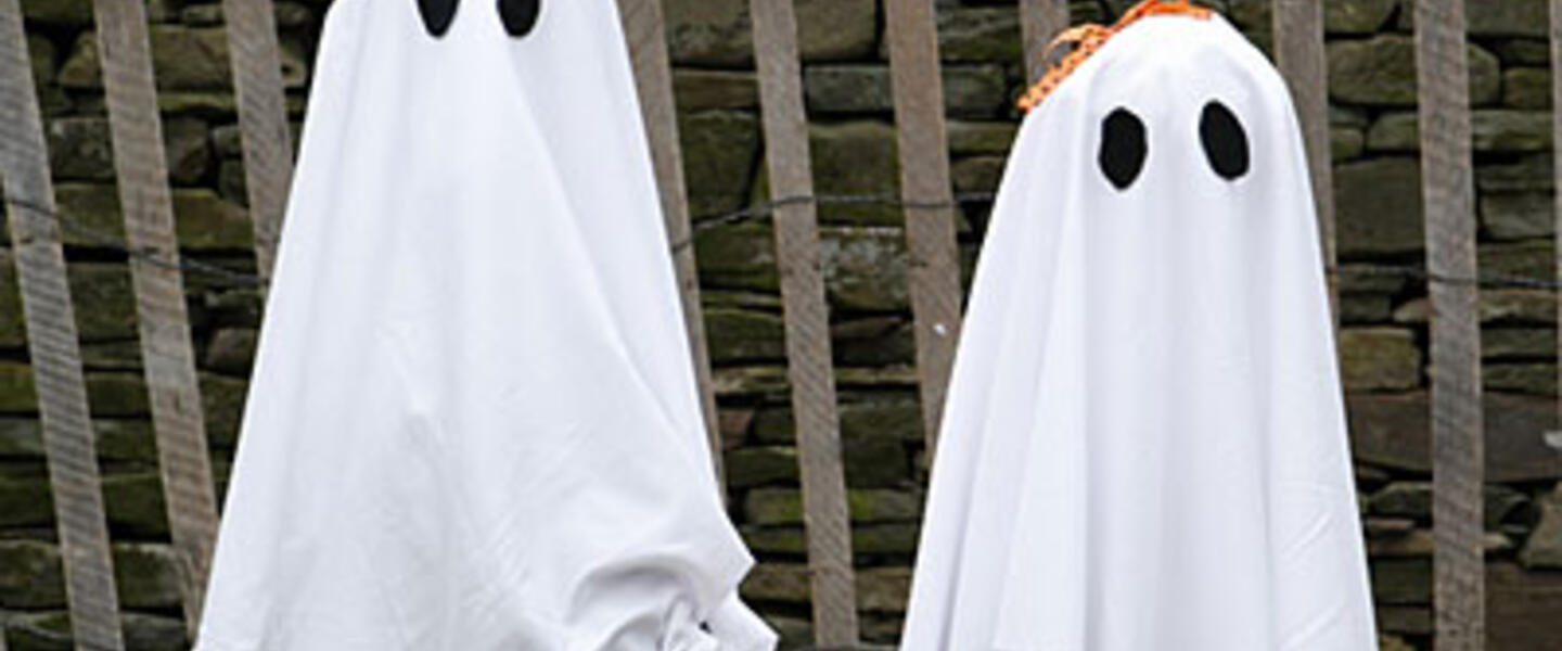A pair of trick-or-treaters in homemade ghost costumes