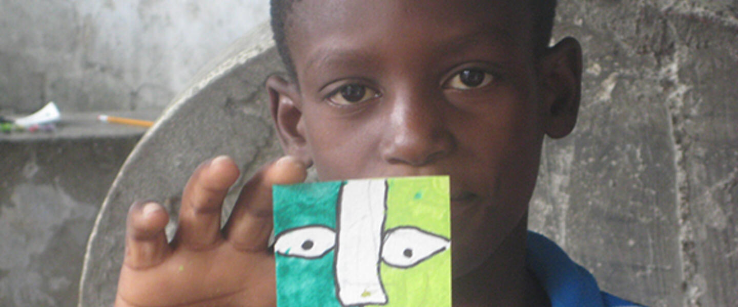 A Haitian student from Project Hope ART holds up his artwork. (Photo courtesy Karen Packer.) A Haitian student from Project Hope ART holds up his artwork. (Photo courtesy Karen Packer.)