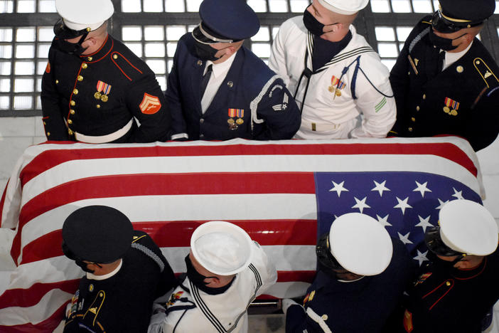 A military honor guard carries the casket of Rep. John Lewis into the Georgia State Capitol.