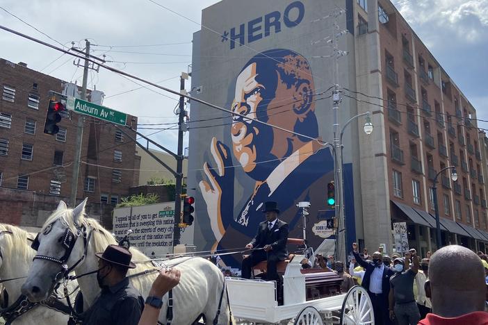 John Lewis' casket passes by his mural in Atlanta.