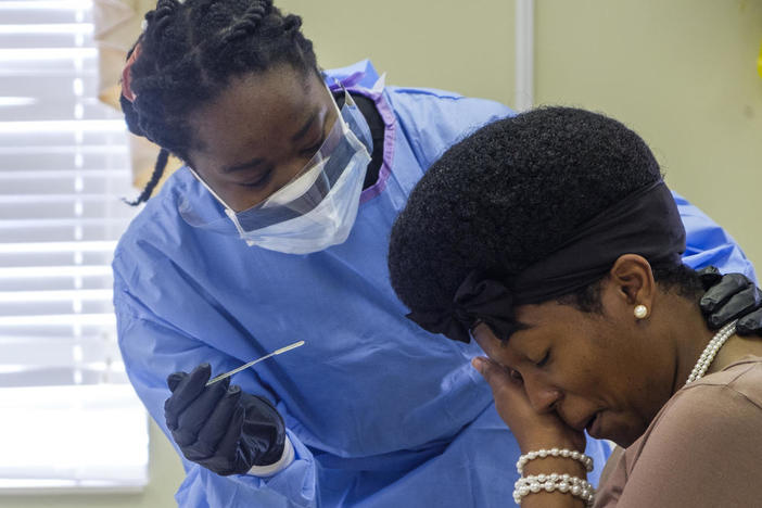 Precious Burnette takes a pause before the second of two nasal swabs during a coronavirus test in Macon.