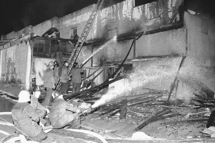 Firemen spray a stream of water on the burned-out shell of a grocery store in Augusta, Ga., May 12, 1970.