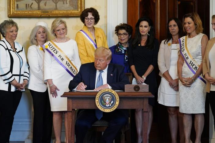 President Donald Trump signs a proclamation recognizing the 100th anniversary of the ratification of the 19th Amendment, Tuesday, Aug. 18, 2020, in the Blue Room of the White House in Washington.