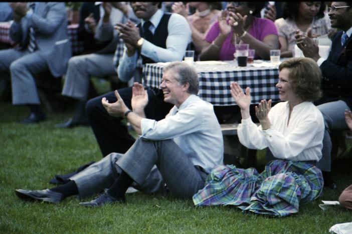 Jimmy and Rosalynn Carter sitting on lawn enjoying the show.