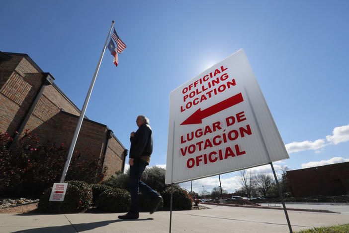 A sign outside of a polling location guides voters inside.