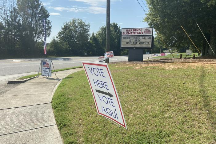 A sign points to a polling location in front of an elementary school.