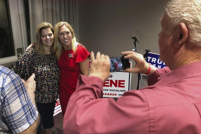 FILE - In this Tuesday, Aug. 11, 2020 file photo, Supporters take photos with construction executive Marjorie Taylor Greene, background right, late in Rome, Ga. 