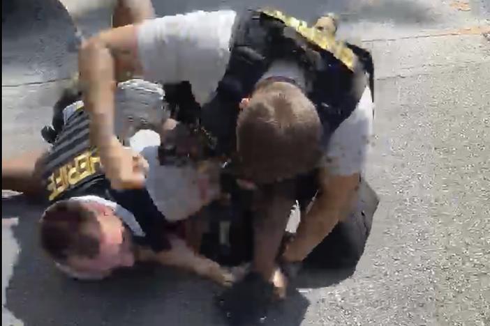 In this screen grab from video shot by Juanita Davis and provided by The Cochran Firm, a Clayton County, Ga., sheriff’s deputy holds down Roderick Walker while another deputy punches him while on the ground, Friday, Sept. 11, 2020, following a traffic stop.