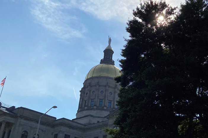 The Georgia state capitol peeks out from behind the trees in Atlanta Georgia.