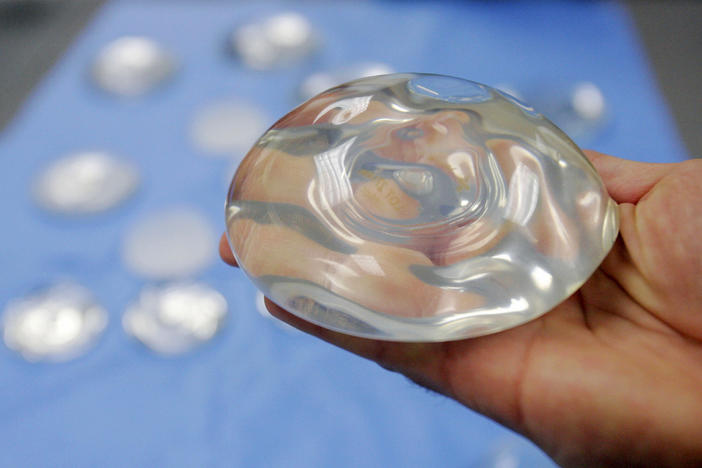 A breast implant held in a hand