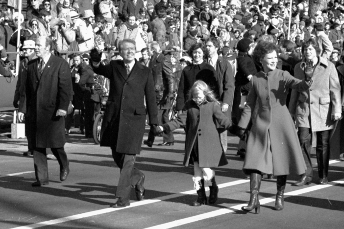 Jimmy and Rosalynn​ Carter hold hands of their daughter Amy, as they walk down ​Pennsylvania Avenue. Inauguration, January 20, 1977.