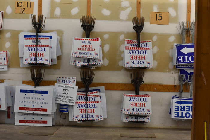 Voting signs line a DeKalb County warehouse.