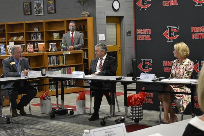Georgia Schools Superintendent Richard Woods talks with U.S. Secretary of Education Betsy DeVos during a September discussion about school reopenings at Forsyth Central High School.
