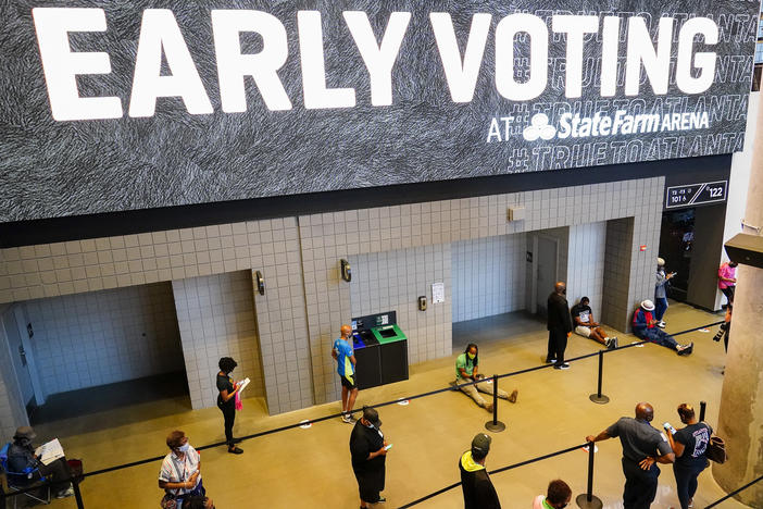 People wait in line to vote early at the State Farm Arena on Monday, Oct. 12, 2020, in Atlanta.