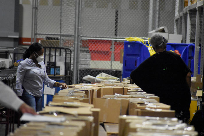 Workers sort through ballots in Fulton County's election warehouse.
